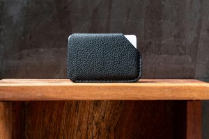 Featured image for an article covering minimalist wallets for men and women. This image shows a simple, slim and minimalist leather wallet in black color.